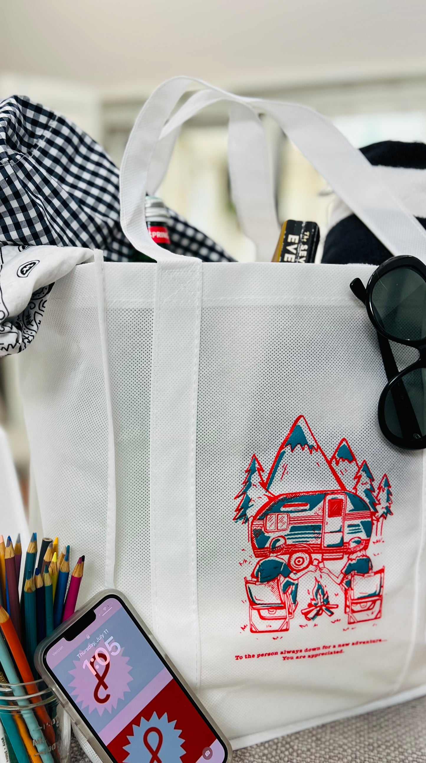 White canvas tote bag with a retro adventure illustration featuring a van, mountains, and trees